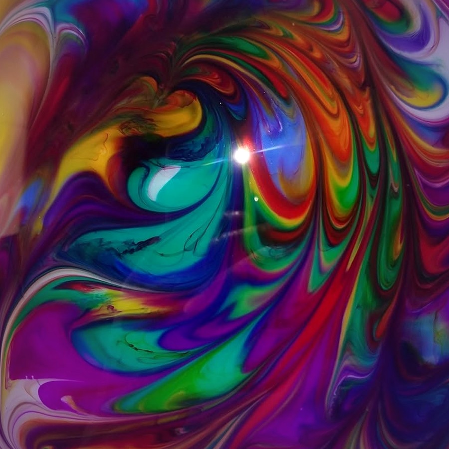 Close-up of swirling resin pigment in purple, teal, orange and red